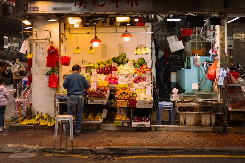 Man selling fresh fruits at a local market. Buying from local market is another genius travel hack.