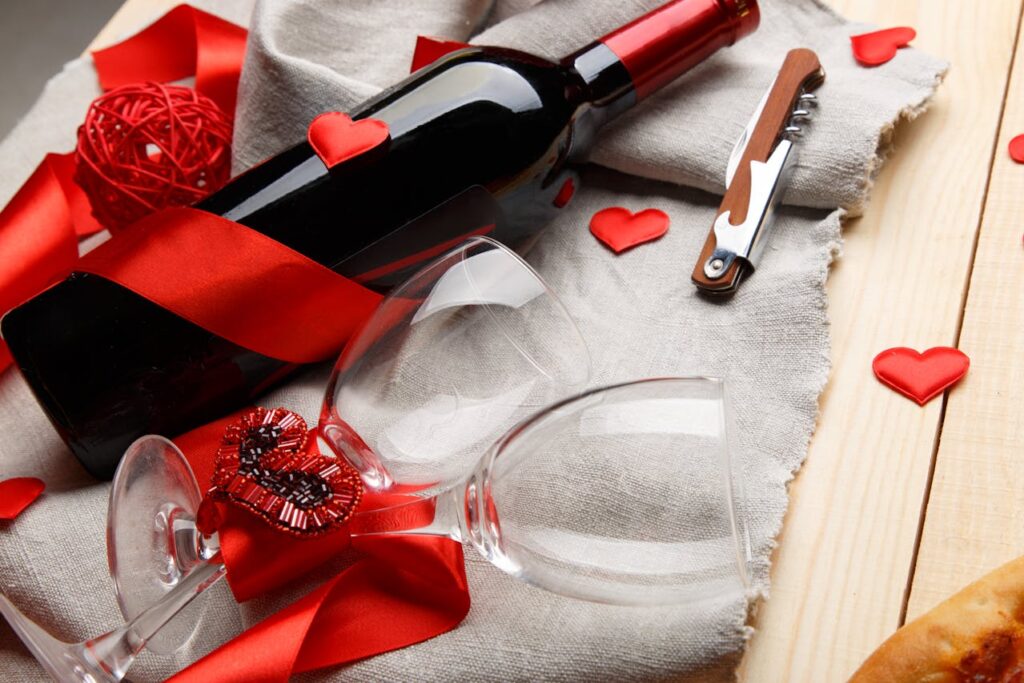 A beautifully wrapped wine bottle with elegant wine glasses, a bottle opener, and a red ribbon—perfect as custom Valentine’s Day gifts for a romantic Valentine’s Day 2025 celebration.