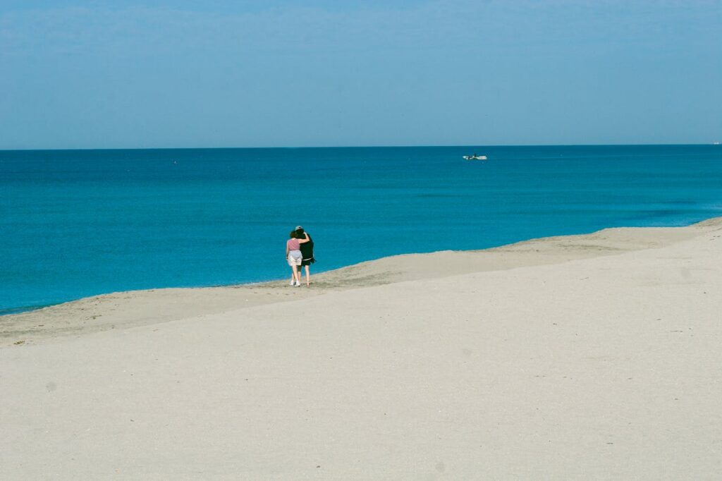 A romantic couple walks hand in hand along the pristine Bora Bora island beach, surrounded by turquoise waters and stunning tropical scenery, enjoying a Valentine’s Day romantic escape.