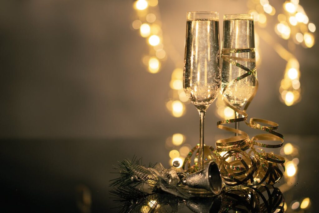 Elegant champagne glasses presented as custom Valentine’s Day gifts against a warm yellow-lit background, celebrating Valentine’s Day 2025 in style.