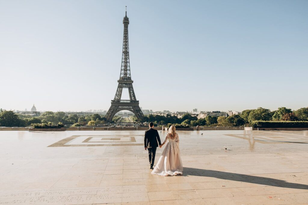 A romantic couple walks hand in hand near the Eiffel Tower, celebrating Valentine’s Day 2025 with a dreamy romantic escape in Paris.