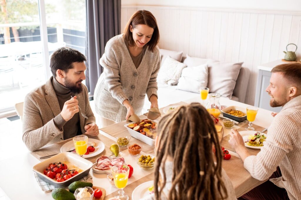 A host serving food to Airbnb guests, showcasing hospitality and the guest experience when learning how to start an Airbnb business.