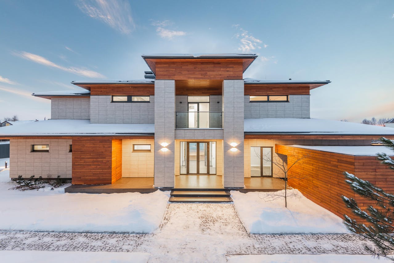 A beautifully lit home surrounded by snow in winter, representing seasonal charm for how to start an Airbnb business.