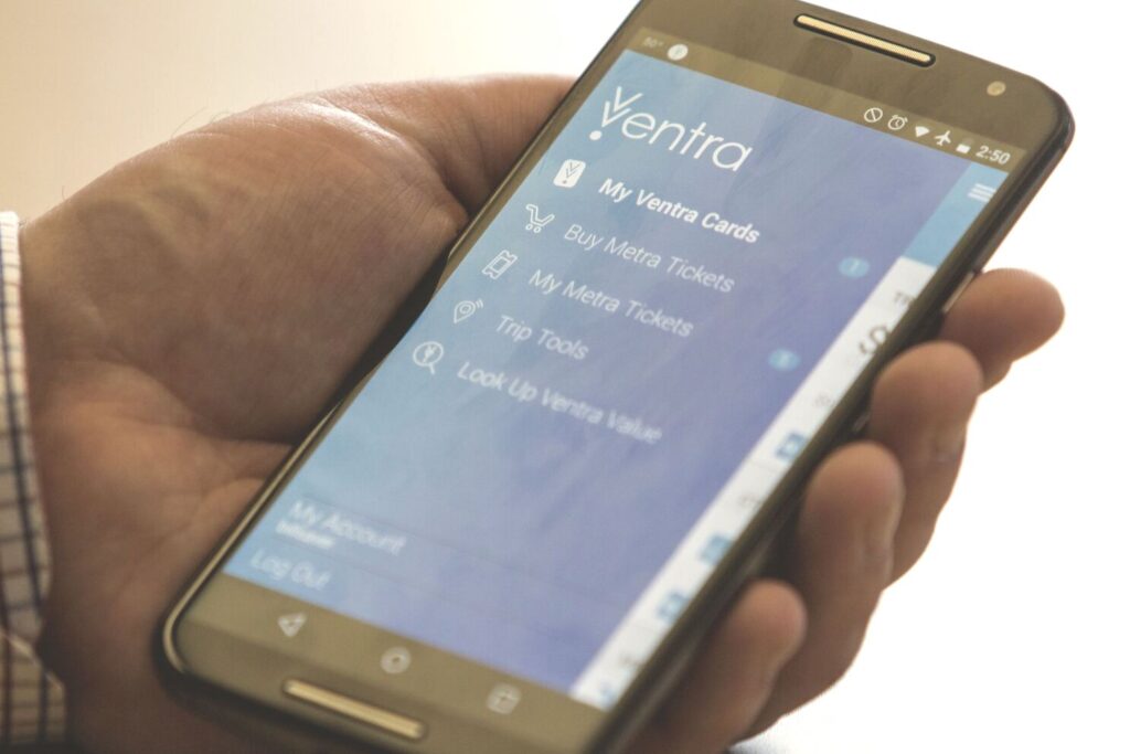A person holding a smartphone with the Ventra App open, showing the transit interface used across Chicago’s public transportation system.