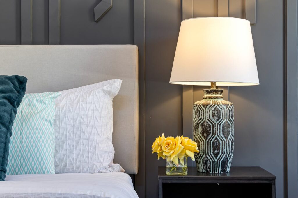 Bedroom side table with yellow roses in vase showing elegant flower decoration at home.
