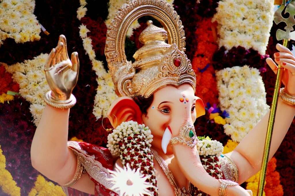 Ganesh idol with colorful flowers and floral backdrop – Ganapati decoration at home