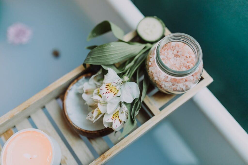 Flower decoration at home with spa essentials placed on the edge of a washroom tub.