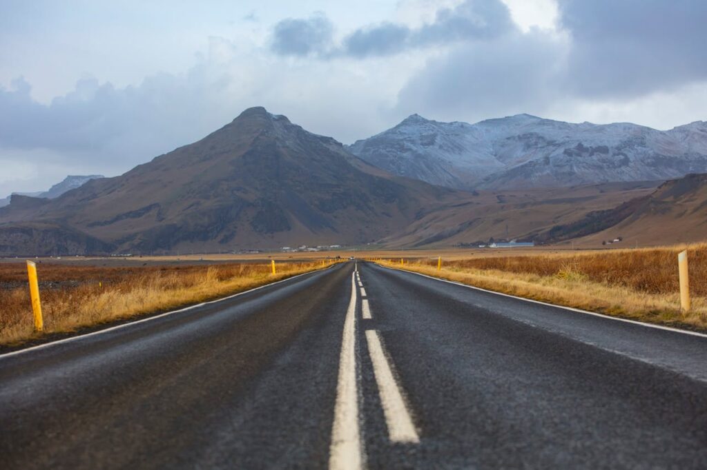 Scenic drive along Iceland's Ring Road with mountains in the background, perfect for an Iceland travel itinerary.