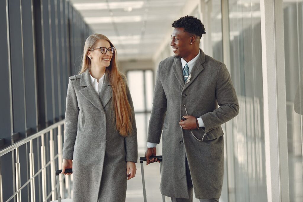 Business couple walking in airport to board plane, representing Amex GBT competitors in corporate travel management