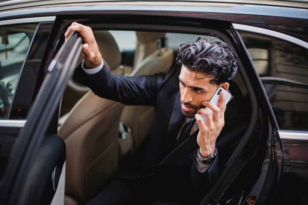 Business traveler arriving at airport in luxury car to board plane, showcasing Amex GBT competitors in premium corporate travel