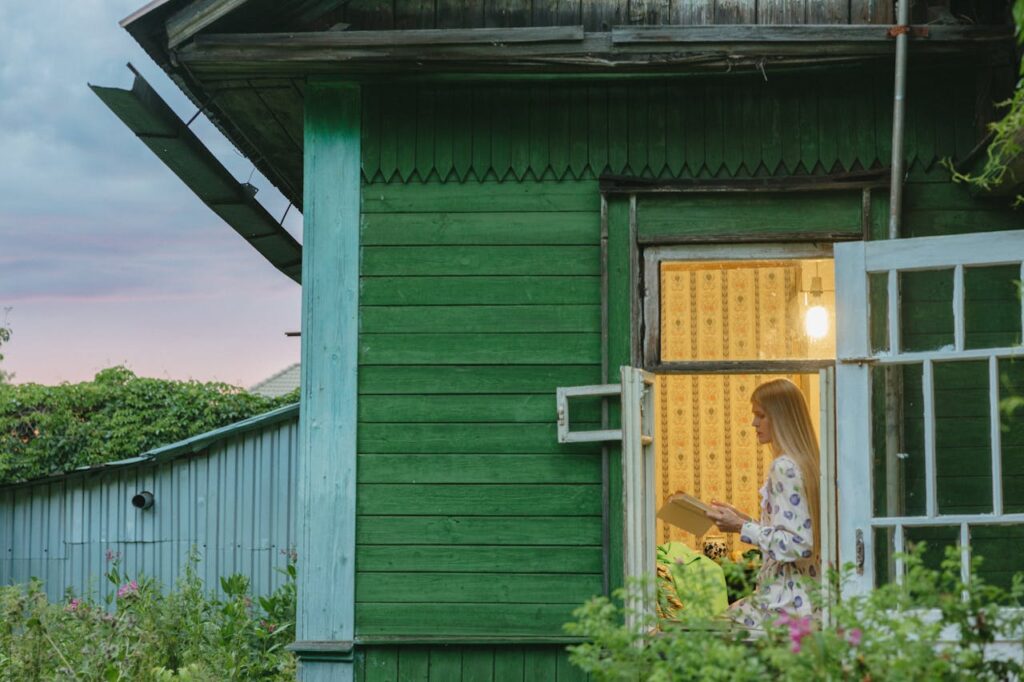 Cozy green Airbnb with guest reading near window, styled to get featured on Airbnb