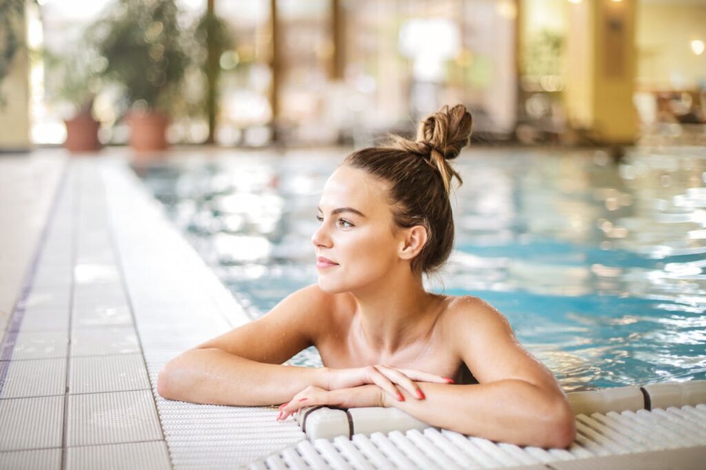 Woman swimming at a luxury resort pool safely, preventing risks like brain eating amoeba through clean and treated water.