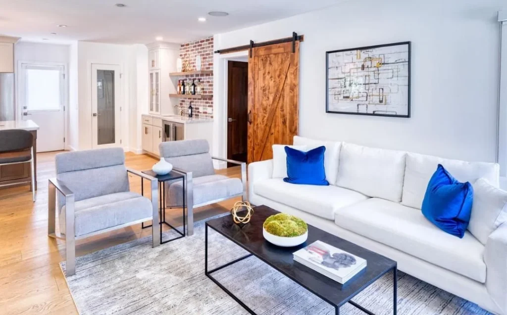 Stylish Airbnb living room with couches, wall decor and warm lighting showing how to increase Airbnb bookings